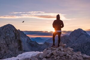 Male hiker in the vast mountain landscape at sunset.