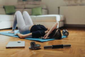Tired woman lying on a fitness mat after her training at home